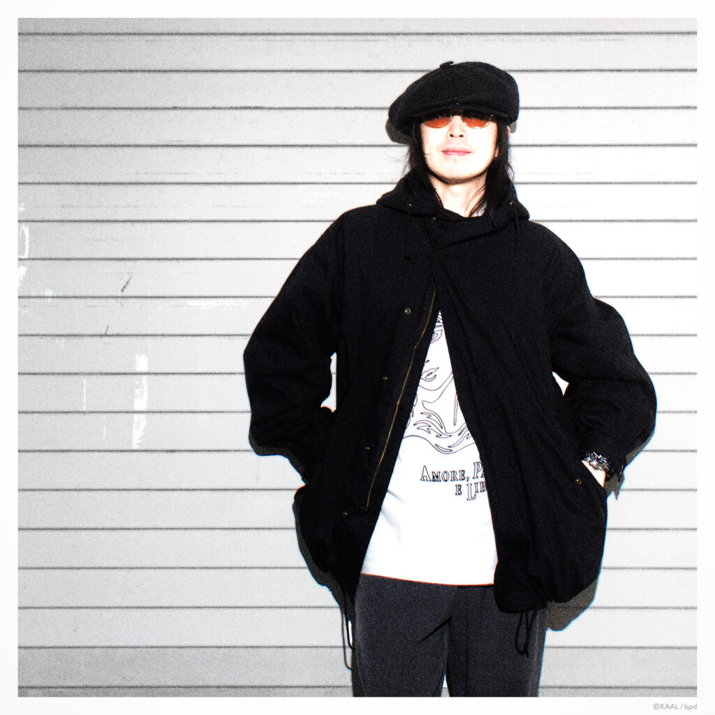 A portrait of artist KAAL wearing a T-shirt he designed himself